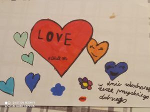 Wielkie czerwone serce w centrum , obok wiele mniejszych z uśmiechami z napisem życzeń wszystkiego dobrego w dniu zakochanych.