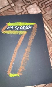 kolorowa siódemka na ciemnym tle kartki z napisem: na szczęście