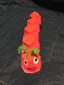 praca przedstawia czerwoną gąsiennicę wykonaną z wytłoczek po jajkach