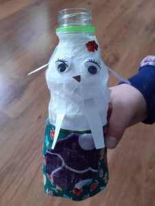 praca przedstawia laleczkę wykonaną z plastikowej butelki oklejoną papierową sukienką
