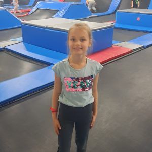 Na zdjęciu widać dziewczynkę z klasy 2 na trampolinie