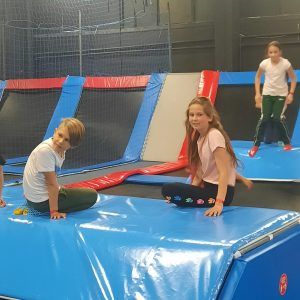 Na zdjęciu widać chłopca i dziewczynkę z klasy 3 siedzących na trampolinie