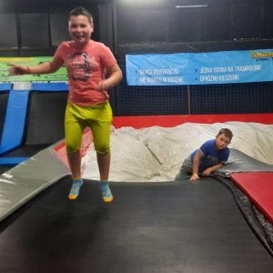 Na zdjęciu widać chłopca w trakcie skoków na trampolinie