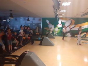 grupa uczniów na kręgielni przygotowuje się do pchnięcia kulą