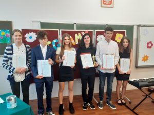 na zdjęciu grupa uczniów ze świadectwami z wyróżnieniem