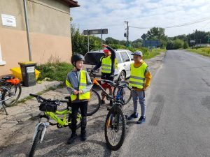 Zdjęcie przedstawia 3 rowerzystów odpoczywających przed sklepem w miejscowości Buchałów.