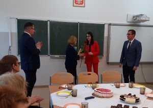 Wójt Gminy Świdnica wręcza nauczycielce nagrodę. Obok stoją Dyrektor szkoły i Przewodniczący Rady Gminy.