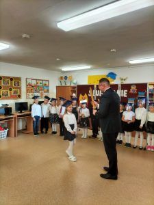 Do dyrektora podchodzi dziewczynka z pierwszej klasy. 