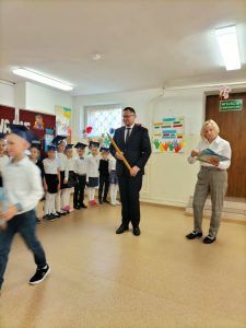 Dyrektor wraz z wychowawcą klasy pierwszej czekają na pasowanie kolejnych uczniów.