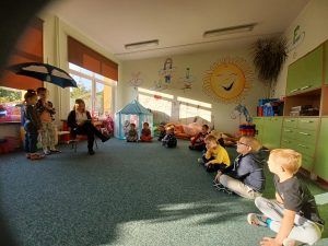 Widoczne dzieci z przedszkola słuchające czytanej książki.