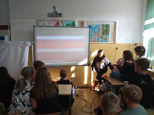 Uczniowie rozwiązują zadanie wyświetlane na ekranie tablicy multimedialnej.