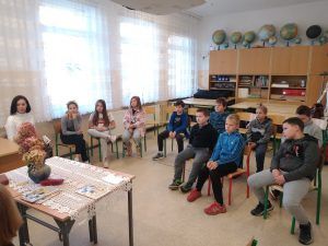 Zdjęcie przedstawia uczniów słuchających czytanej opowieści.