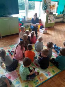 Bibliotekarka czyta przedszkolakom wiersze.