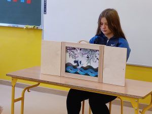 Uczennica prezentuje "Bajkę o Wiśle" Magdaleny Zarębskiej techniką teatru kamishibai w klasie pierwszej.