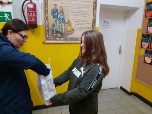 uczennica częstuje cukierkiem pracownika szkoły