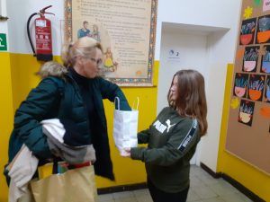 uczennica częstuje nauczyciela cukierkiem