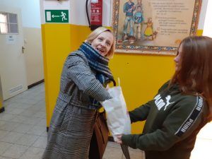 uczennica częstuje nauczyciela cukierkiem