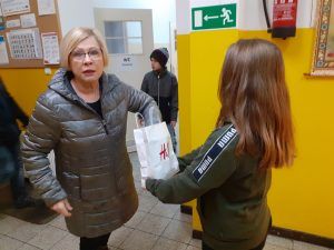 uczennica częstuje pracownika szkoły cukierkiem