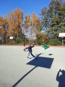 Na zdjęciu uczeń klasy 5 biegnie po boisku ze swoim latawcem