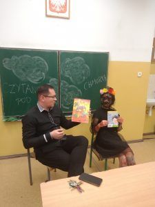 Uczennica wraz z dyrektorem prezentują książki, które zostały odczytane na spotkaniu