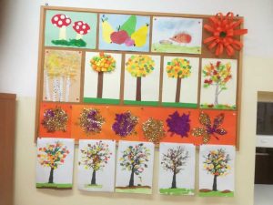 zdjęcie tablicy z pracami prezentującymi jesienne drzewa