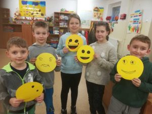 grupa dzieci z wykonanymi przez siebie uśmiechniętymi buźkami