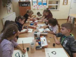 grupa uczniów wykonujących prace plastyczne
