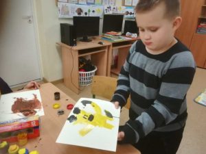 uczeń z pracą, którą jest żółty miś