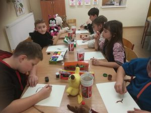 grupa uczniów podczas wykonywania pracy plastycznej o misiach