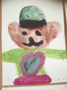 miś z wielkim serduszkiem na brzuszku i zielonym kapeluszem na głowie