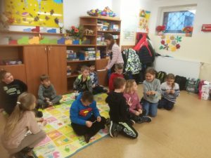 zdjęcie przedstawia dzieci wróżące sobie na dywanie