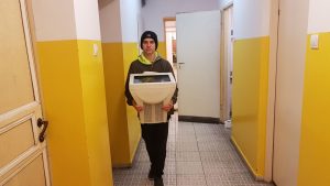 uczeń niosący komputer