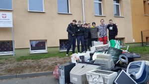 grupa uczniów przed zebranym sprzętem elektronicznym
