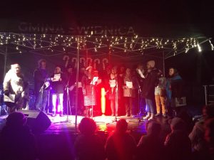 duża grupa dorosłych śpiewająca kolędy na scenie