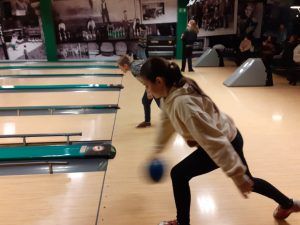 Fotografia 2 przedstawia dziewczynkę i chłopca w momencie rzucania kuli na tor.