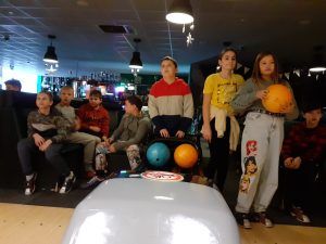 Na fotografii 7 dzieci przed podajnikiem kul analizują wyniki na tablicy.