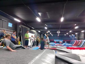 Uczniowie pod okiem trenera przygotowują się do skoku w piankowy basen