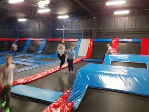 Kilkoro uczniów na trampolinach