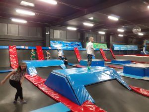 Kilkoro uczniów korzystających z trampolin