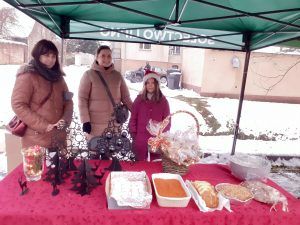 stoisko ze słodkościami i ozdobami świątecznymi a przy nim nauczycielka, rodzic i uczennica