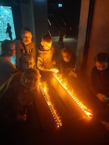 dzieci dotykają imitacji ognia utworzonej ze światła i pary wodnej