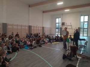 uczniowie na sali gimnastycznej podczas koncertu