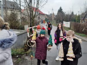 uczniowie idący ze swoimi pracami do Domu Seniora