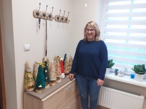 pracownik Domu Seniora wraz z choinkami przekazanymi dla podopiecznych