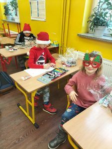 na zdjęciu dzieci rozpakowują swoje paczki mikołajkowe