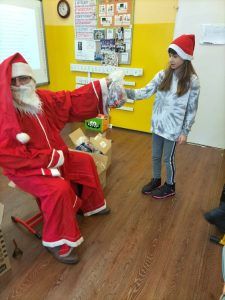 na zdjęciu Mikołaj wręcza dziewczynce paczkę 
