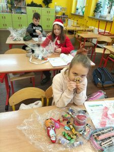 dzieci przy ławkach z paczkami słodyczy