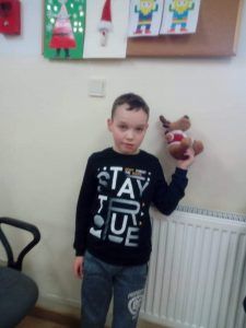 chłopiec z pluszowym reniferem w ręce