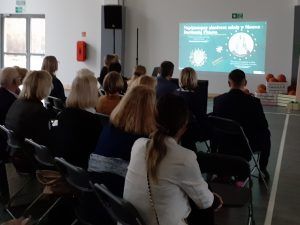 na zdjęciu goście oglądający prezentację opisującą historię szkoły