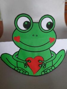 na kartce zielona żabka z czerwonym serduszkiem w łapkach